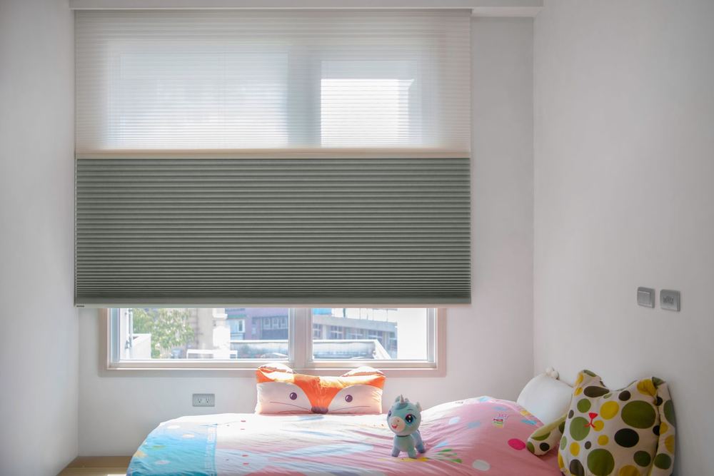 Grey day/night honeycomb shade in a child's bedroom