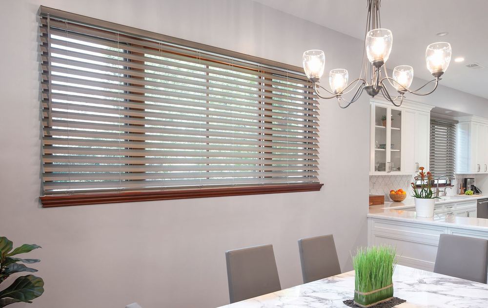 Normandy® wood blinds in a driftwood finish on a wide dining room window