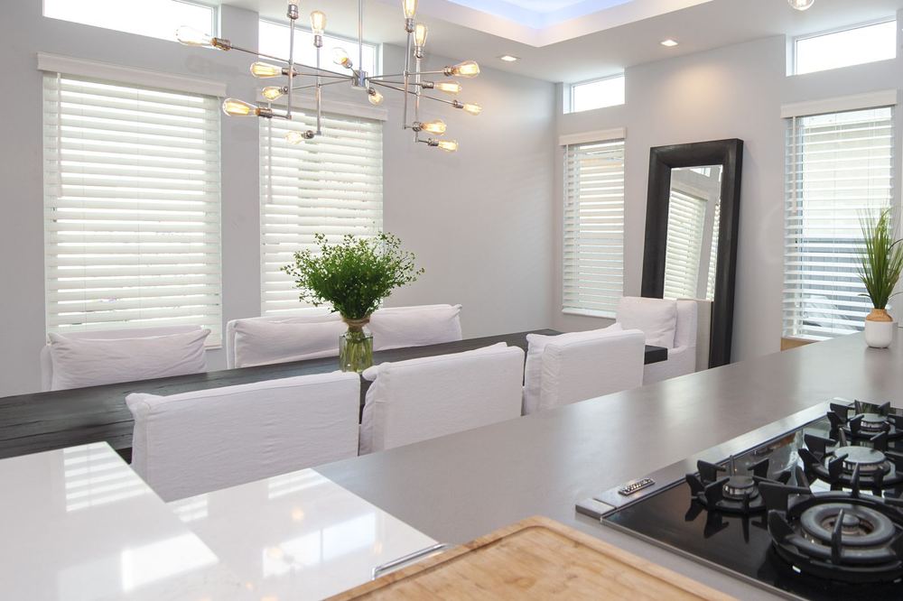 White Normandy® wood blinds on tall dining room windows