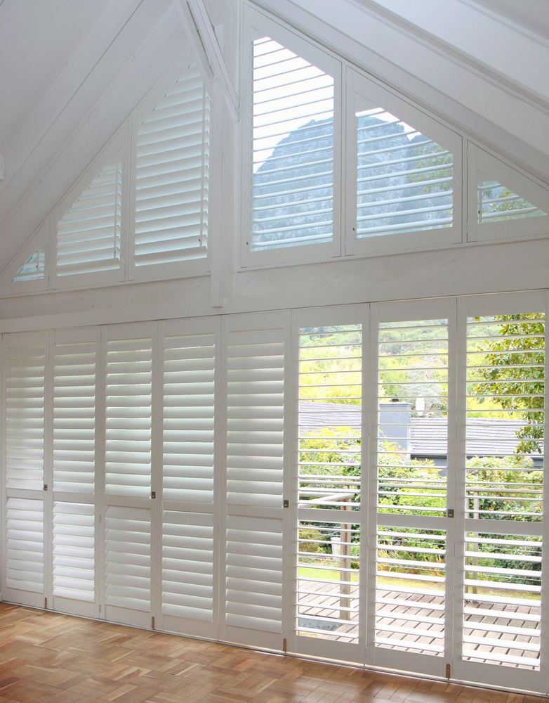White triangular gable shutters above full-height shutter panels