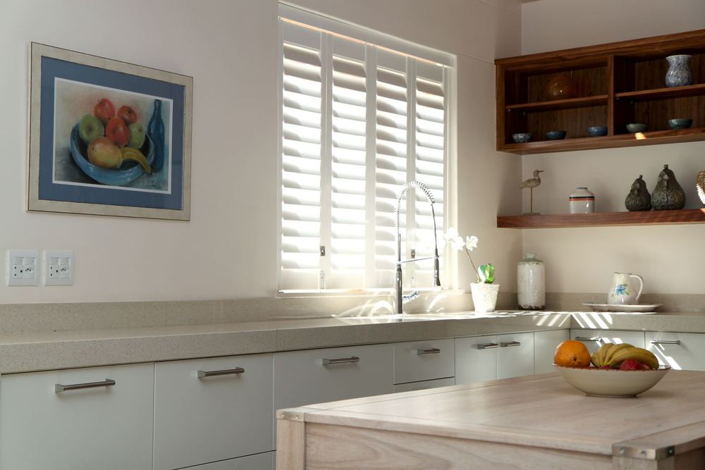 White Woodlore® Plus shutters on a kitchen sink window
