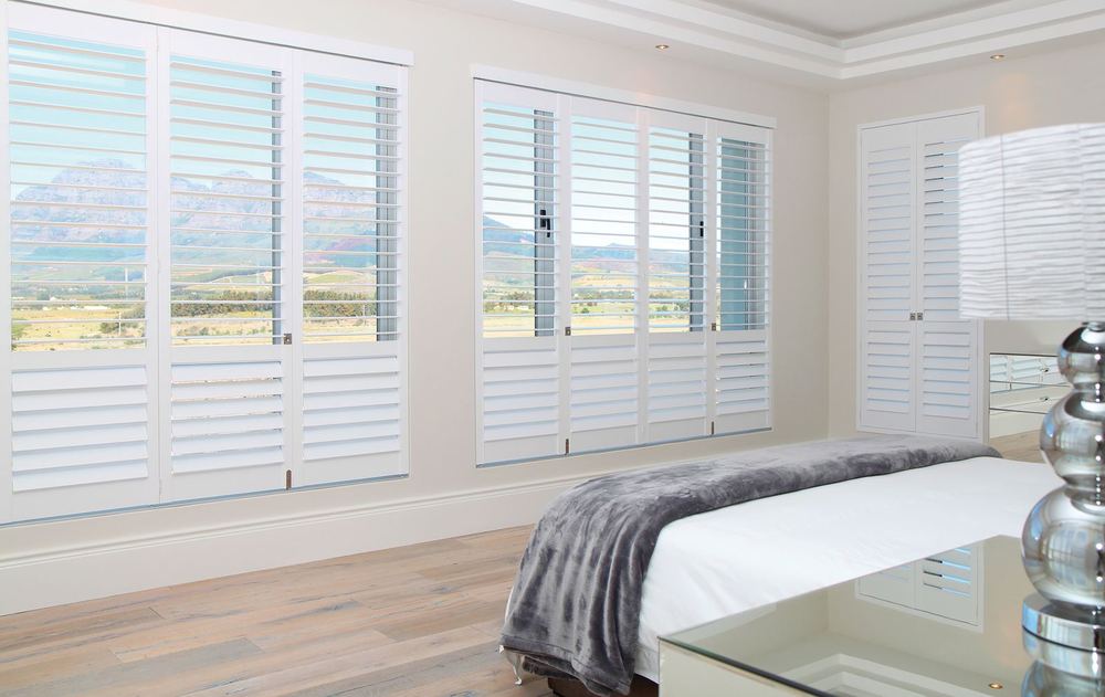 White Woodlore® shutters across bedroom windows